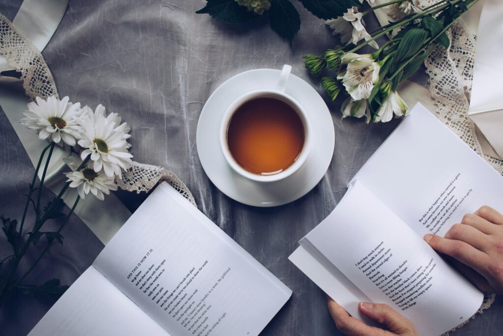 A photo of opened books with a cup of tea.